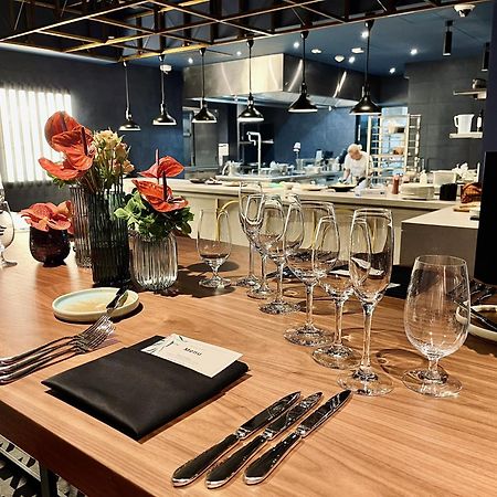 Royal Tulip Warsaw Centre Aparthotel Exterior foto The photo shows a beautifully arranged dining area in a restaurant. There is a long wooden table set with elegant glassware, including wine glasses and water glasses. Each place setting includes polished silverware and a folded napkin with a card on 